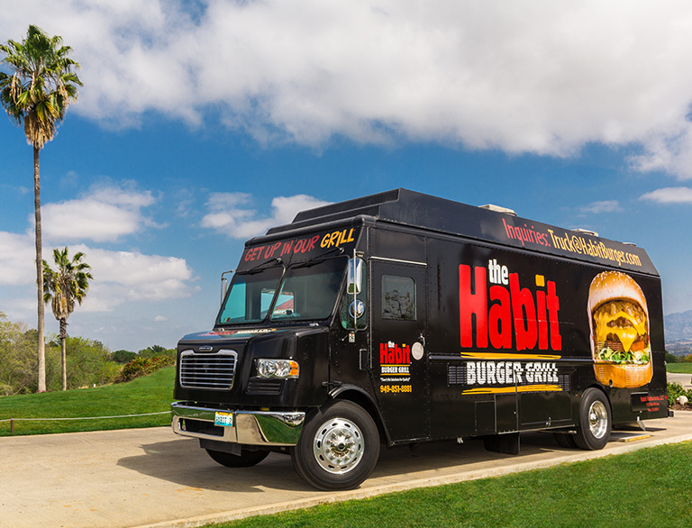 The Habit Burger Grill catering truck against a blue sky
