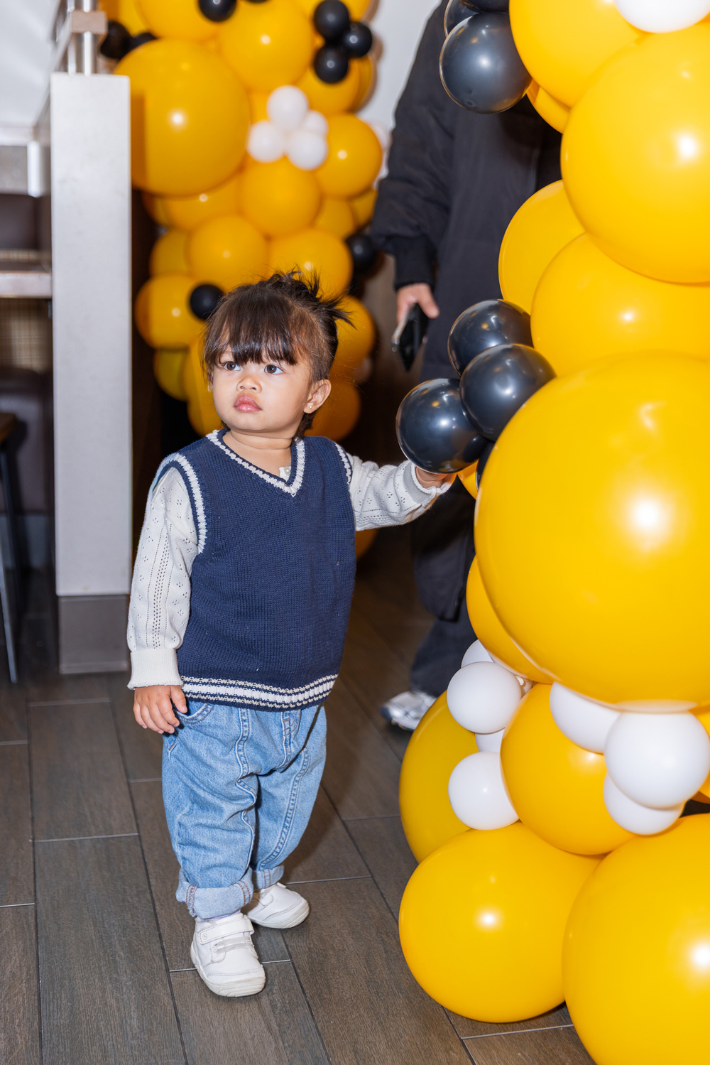 Toddler standing next to balloon display at Good Habits Day