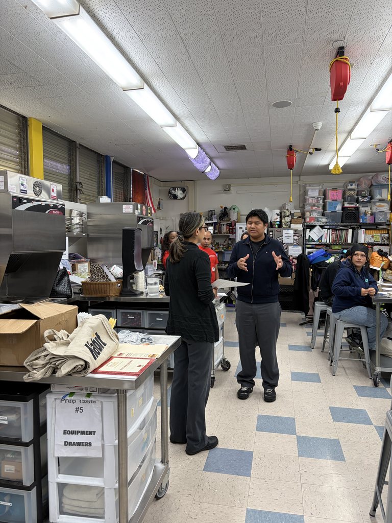 Habit volunteer talking with a high school student in a culinary classroom during FIT Day 2026